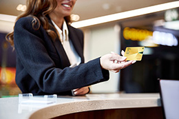 Young woman using gold card and smiling